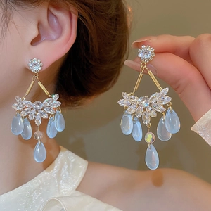 Golden drop earrings with sparkling cubic zirconia and light blue teardrop beads detail