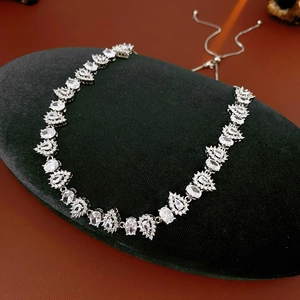 Detailed view of silver zircon water drop necklace on black velvet display pad