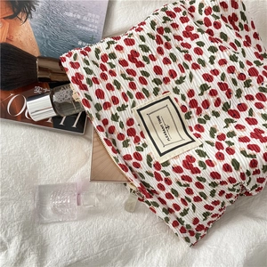 Close-up of floral pleated makeup bag with PLEASANT TIME label and metal zipper