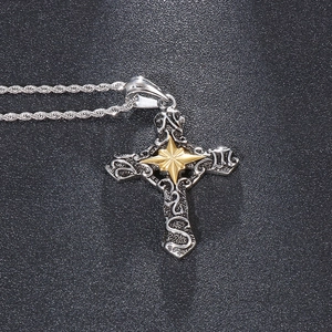 Macro shot of gothic cross pendant with silver rope chain and gold star detail