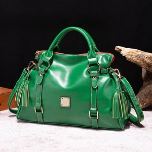 Bolso de cuero verde oscuro con herrajes dorados, borlas laterales y correa extraíble