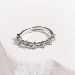 Close-up of adjustable silver ring with wavy texture and white cubic zirconia stones