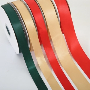 Detail of satin ribbons in green, gold, and red with smooth glossy finish for gift wrapping