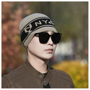 Photo de mannequin en extérieur portant un bonnet en tricot rayé noir et blanc avec NY