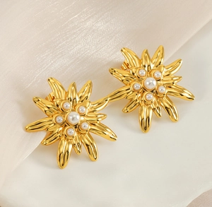 Detailed close-up of vintage flower earrings with pearls and golden metallic starburst