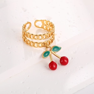 Detail shot of golden Cuban chain ring with red enamel cherry charm and open band