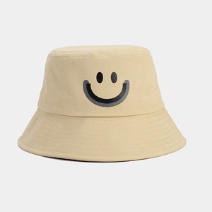 Detail shot of beige cotton twill bucket hat with minimalist black smiley face print