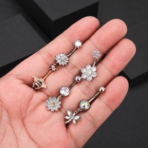 Macro shot of silver and rose gold belly rings featuring bee and butterfly zircon designs