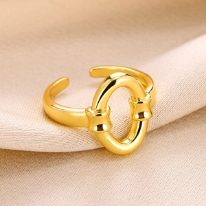Close-up of gold-plated interconnected ring on soft beige silk fabric background