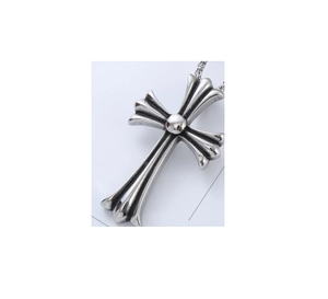 Close-up of vintage silver cross pendant with intricate engravings and retro metal finish