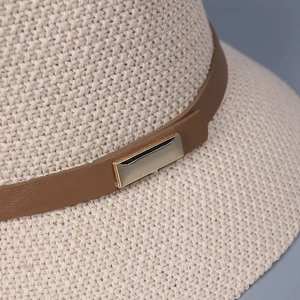 Women's woven straw sun hat with brown leather band and gold buckle detail