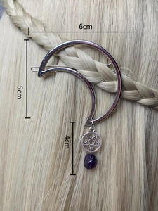 Detail of moon hair clip with star and purple gemstone pendant worn on braided hair