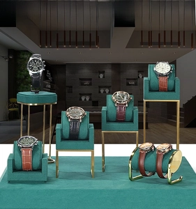 Detail of luxury green velvet and gold metal jewelry stand display set for watches