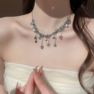 Détail du collier à pampilles papillon et étoile avec perles sur le cou du modèle