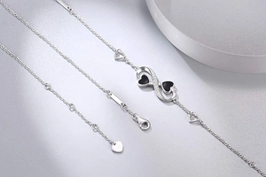 Detail of 925 sterling silver infinity bracelet with black hearts and S925 stamp