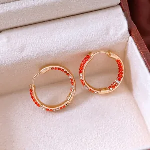 Boucles d'oreilles créoles dorées avec pavage de zircons rouges pour un style chic