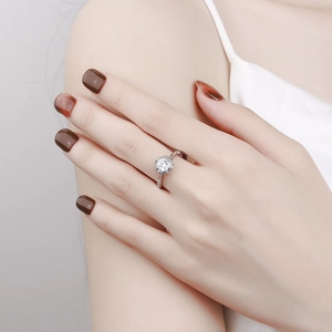 Elegant flower shaped silver ring with a sparkling clear zircon stone worn on a finger