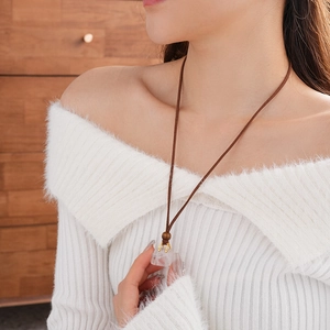 Detail of faux stone pendant with wooden beads on a brown leather cord necklace