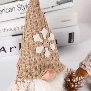 Handcrafted Christmas gnome with brown knit hat and plush beard on white book decor