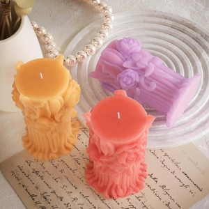 Detailed relief of roses on Roman column scented candles in orange, pink, and purple