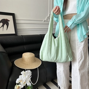 Detail of mint green tote bag with bubble pleat texture and soft fabric finish