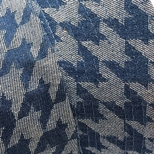 Close-up of navy blue and white houndstooth fabric texture with fine stitching detail