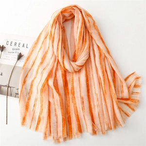 Orange gradient linen-feel scarf with gold foil details and fringe edges on a white background