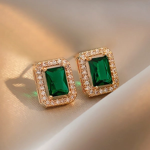 Macro detail of vintage emerald cut green earring with white diamond halo on gold base