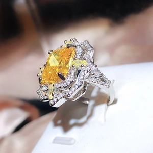 Macro detail of rectangle yellow high carbon diamond ring with sparkling floral halo