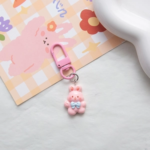 Detail of pink resin rabbit keychain with matching metal clasp and floral accessory