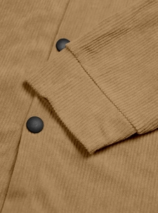 Detailed close-up of corduroy texture with black buttons on a khaki utility shirt