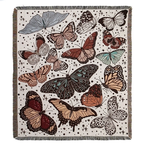 Bohemian woven picnic blanket with colorful butterfly patterns and tassel edges