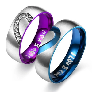 Macro shot of titanium steel couple rings with brushed finish and I Love You engraving