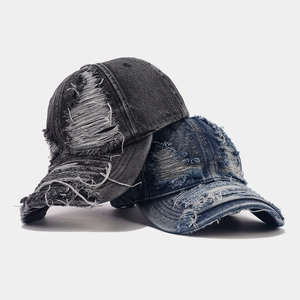 Washed distressed denim baseball cap with vintage frayed holes in grey and blue denim