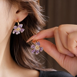Detailed view of vintage flower C-shape earrings featuring purple and white beads