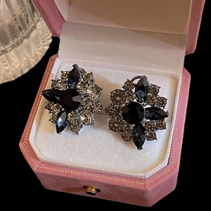 Detailed view of floral crystal stud earrings resting in a pink velvet jewelry box