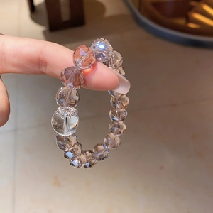 Detail of faceted champagne crystal bead bracelet with silver hollow floral charm spacer