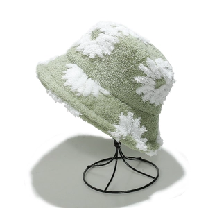 Detailed texture of light green teddy fleece bucket hat with white flower pattern