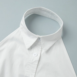 Detail of white cotton detachable fake collar featuring classic pointed lapel and buttons