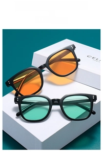 Detail of square black sunglasses with orange and mint green lenses on display