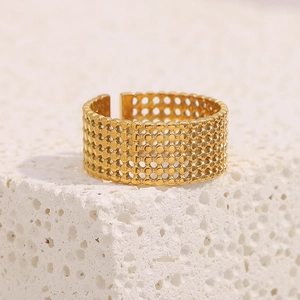 Detailed macro view of 18K gold plated mesh ring on a textured stone pedestal