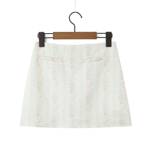 Détail de la mini-jupe trapèze blanche à fleurs avec poches décoratives et imprimé