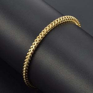 Minimalist gold-plated wheat link bracelet on a black jewelry stand for women