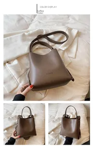 Detail view of coffee-colored bucket bag showing the smooth texture and MAGGHEE logo