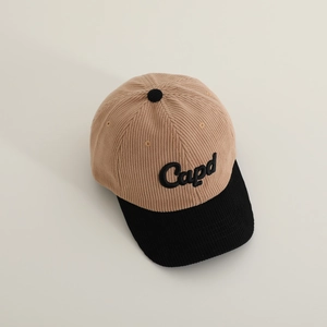 Detailed close-up of khaki and black corduroy baseball cap with embroidered Capd logo
