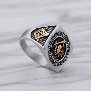 Macro detail of bicolor masonry ring with skull engraving on marble background