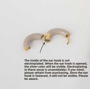 Vue détaillée du mécanisme de charnière interne de la boucle d'oreille dorée émaillée beige
