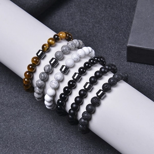 Detailed view of six natural stone bracelets including tiger eye and black volcanic rock