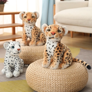 Three realistic plush leopards sitting on a straw mat with detailed faux fur patterns