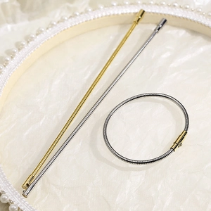 Gold and silver stainless steel snake bone bracelets displayed in a vintage pearl frame